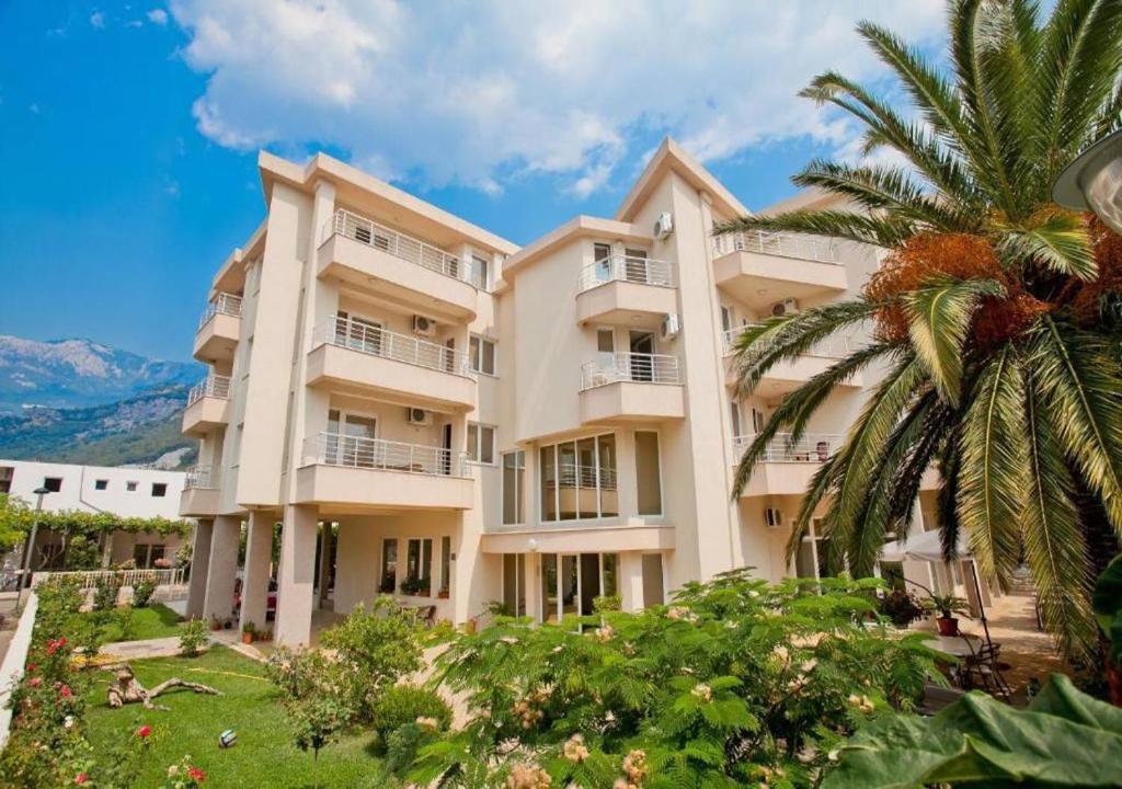 a large apartment building with a palm tree at Residence Bella in Budva