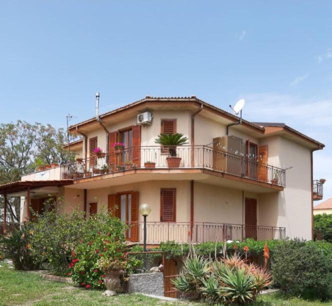 a large house with a balcony and plants at Appartamento Tavernetta Corallo Rosso in Isca Marina