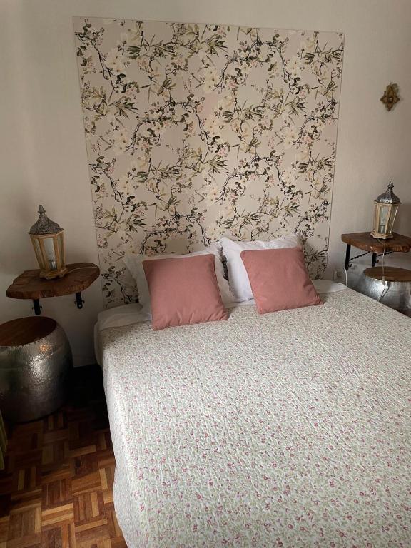 a bedroom with a bed with two pink pillows at Vino Domus in Cabeção