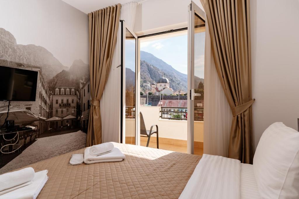 a bedroom with a bed and a large window at Bofima Apartments in Kotor