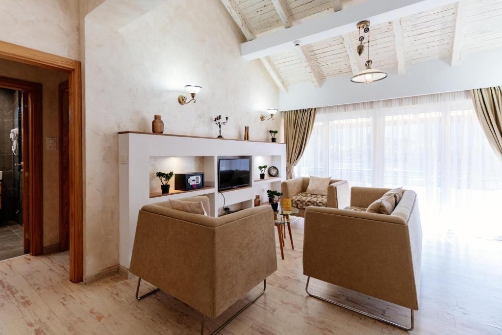 a living room with two chairs and a television at Bofima Apartments in Kotor