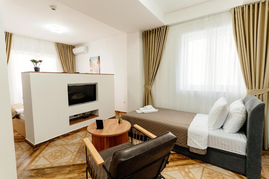 a hotel room with a bed and a couch and a tv at Bofima Apartments in Kotor