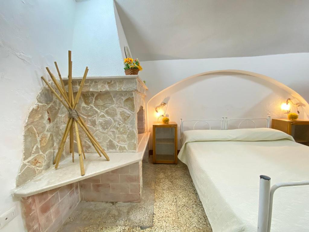 a bedroom with two beds and a stone fireplace at Lo Scoglio Bianco in Gallipoli