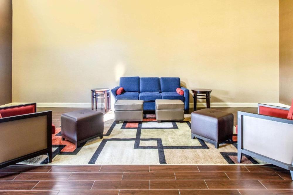 a waiting room with a blue couch and chairs at HOTEL WORLD Inn and Suites in Corbin