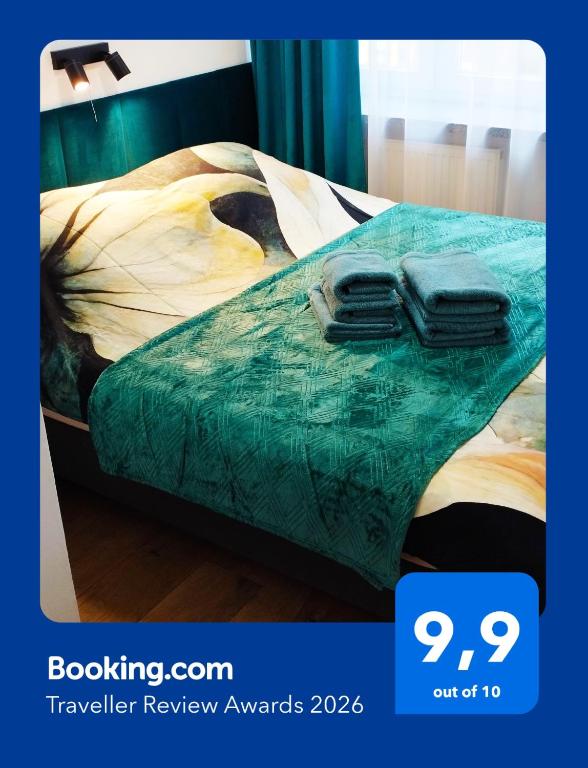 a bed with two towels on top of it at Through the Art Gallery in Piła