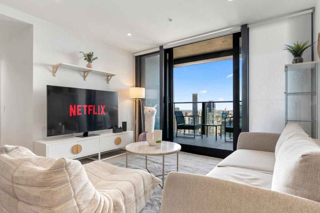 a living room with a tv and a couch at 39th floor luxurious spacious apartment in Melbourne