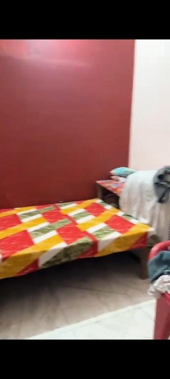 a bed with a colorful blanket on it in a room at Khanna Nagar GDA approved colony in Ghaziabad