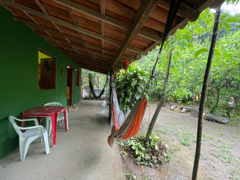a hammock on the porch of a house at Casa oblíqua no Vale do Capão in Palmeiras
