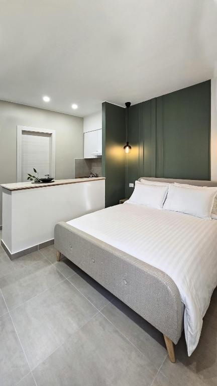 a bedroom with a large bed and a kitchen at MASA 2Rooms in Piazza Armerina