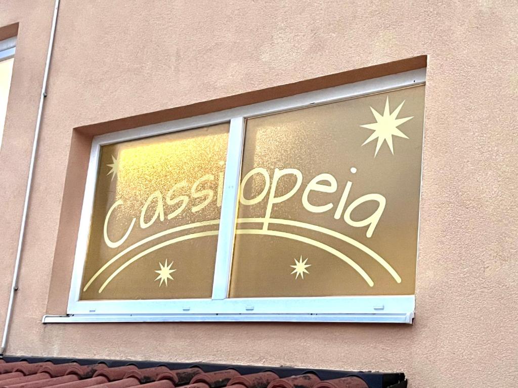 a window of a store with a glass opedia sign at Apartmani Cassiopeia in Murine