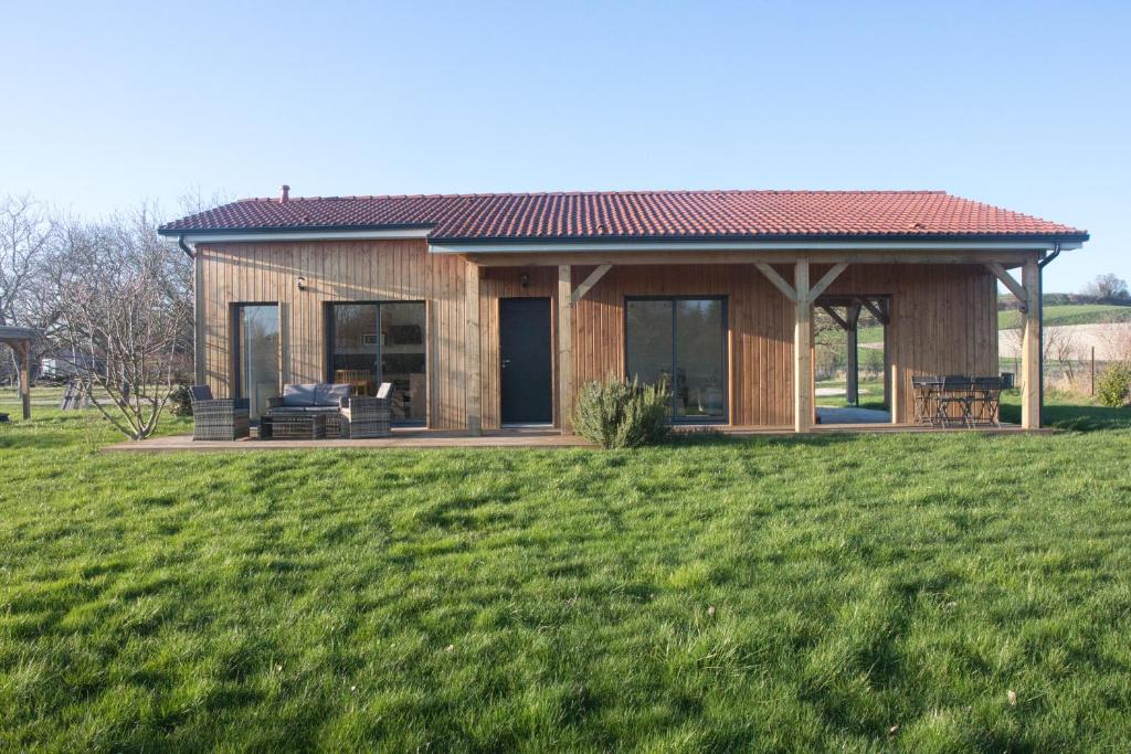 a small wooden house in a field of grass at LE DOMAINE DES SENS - Chalet avec SPA privatif - pleine nature - expérience détente in Hans