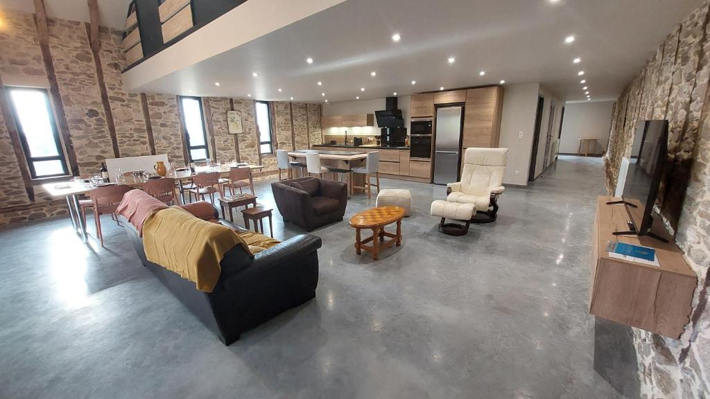 a large living room with couches and a kitchen at Létable de Boissadel in Boisset