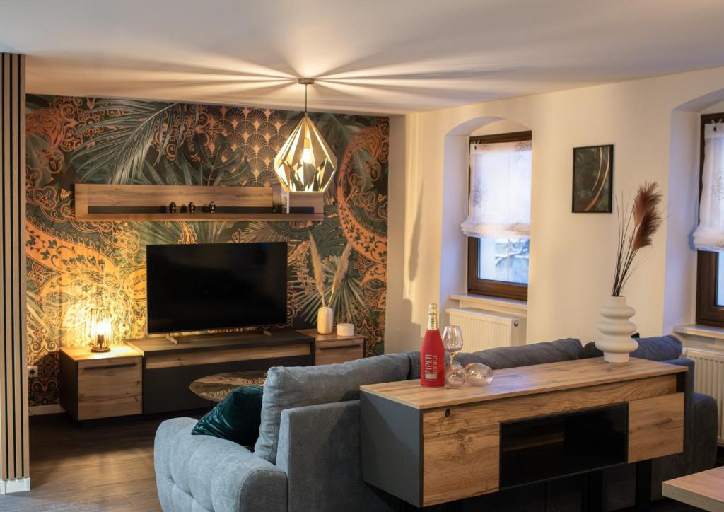 a living room with a couch and a tv at Ferienappartment Sickert in Groß Särchen