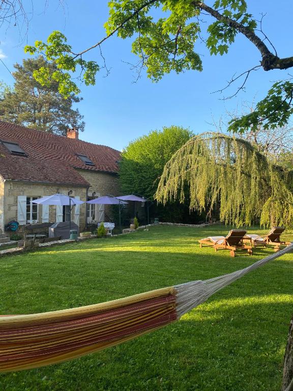 a hammock in a yard next to a house at LE PRESBYTERE in Chasnay