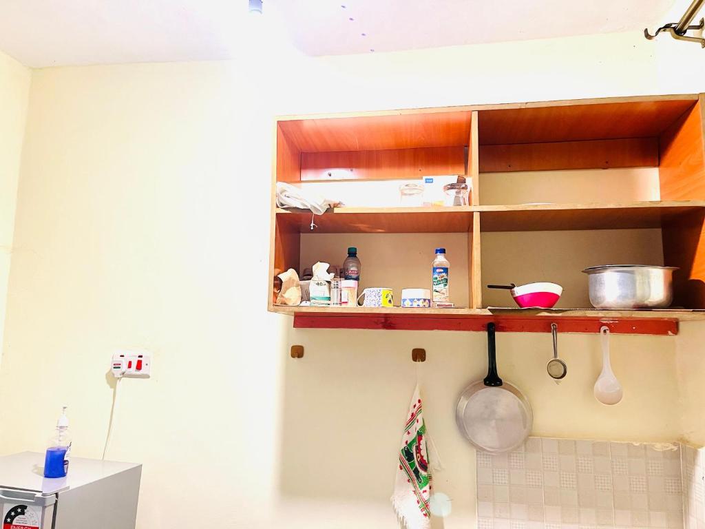 a kitchen with a shelf with ingredients on it at Zion Homes in Taveta