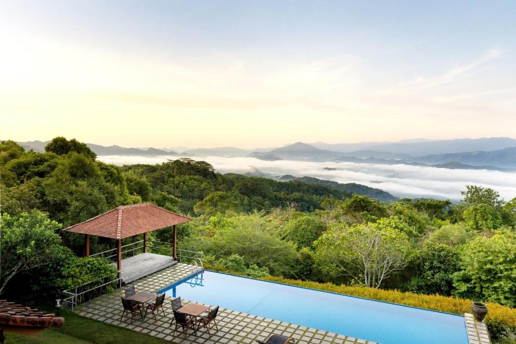 a swimming pool with a view of the mountains at Kandy Knightsdale Villa in Panwila