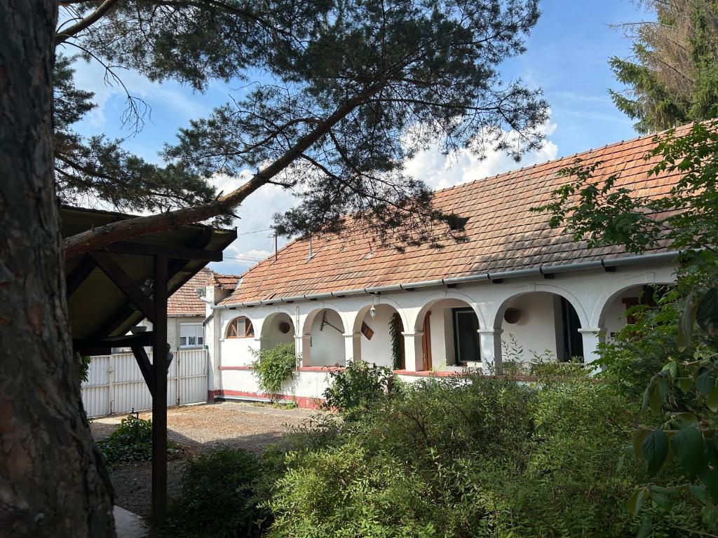 a white house with a red roof at Mandulaág Vendégház in Egerszalók