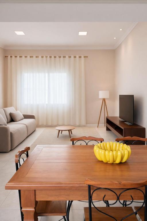 a living room with a table with a bowl of bananas on it at Apê 401 - Central, Garagem e Ar-Condicionado - 2Q in Governador Valadares
