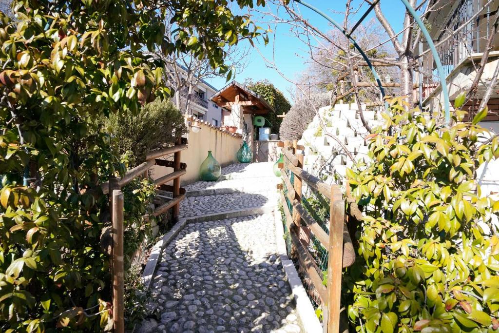 a garden with a fence and a walkway at Villa Kappa - disponibili anche camere climatizzate - in LʼAquila