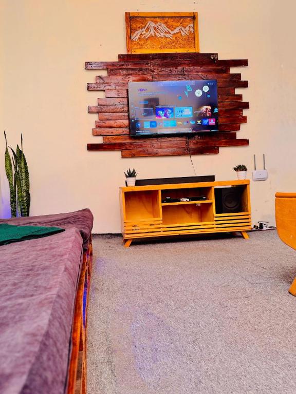 a living room with a flat screen tv on a wall at Makao Home in Arusha