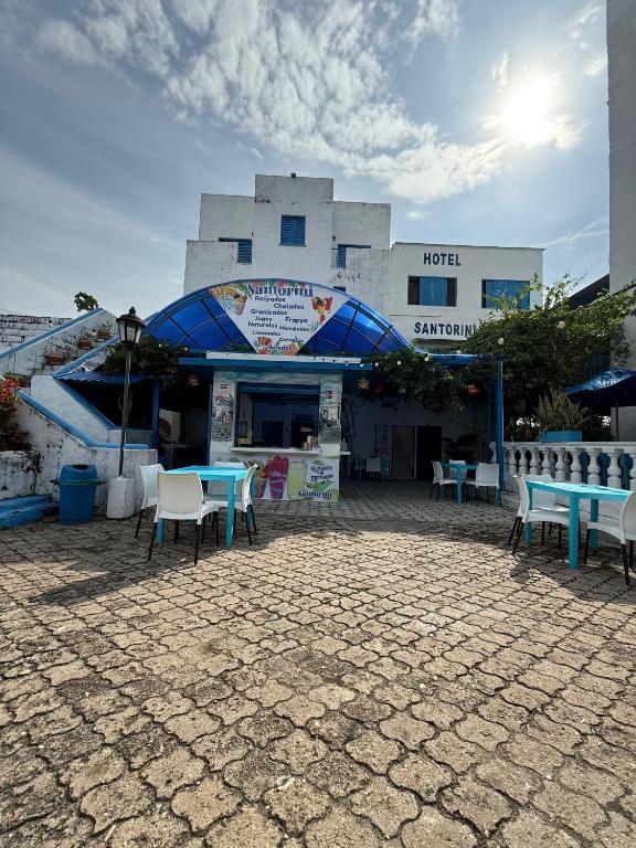 a building with tables and chairs in front of it at Hotel Santorini Doradal in Doradal