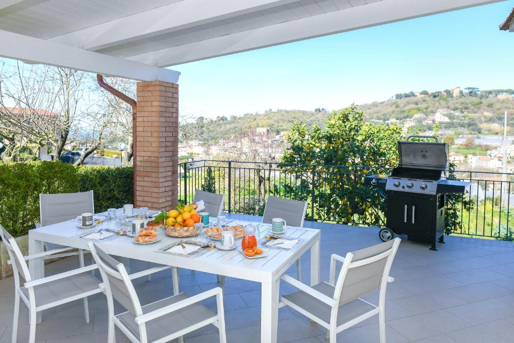 a white table and chairs on a patio with a grill at Casa Saveria in Massa Lubrense