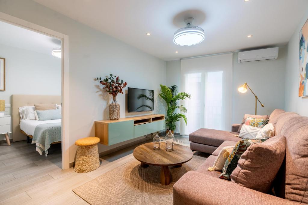 a living room with a couch and a tv at UNIQUE HOMES LAS SETAS LA CAMPANA in Seville