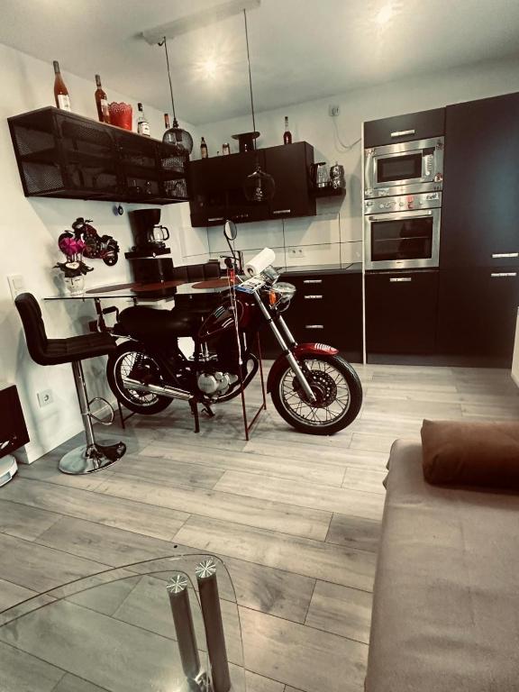 a motorcycle parked in a room with a kitchen at Apartment klein, fein, ruhig und gemütlich in Bochum