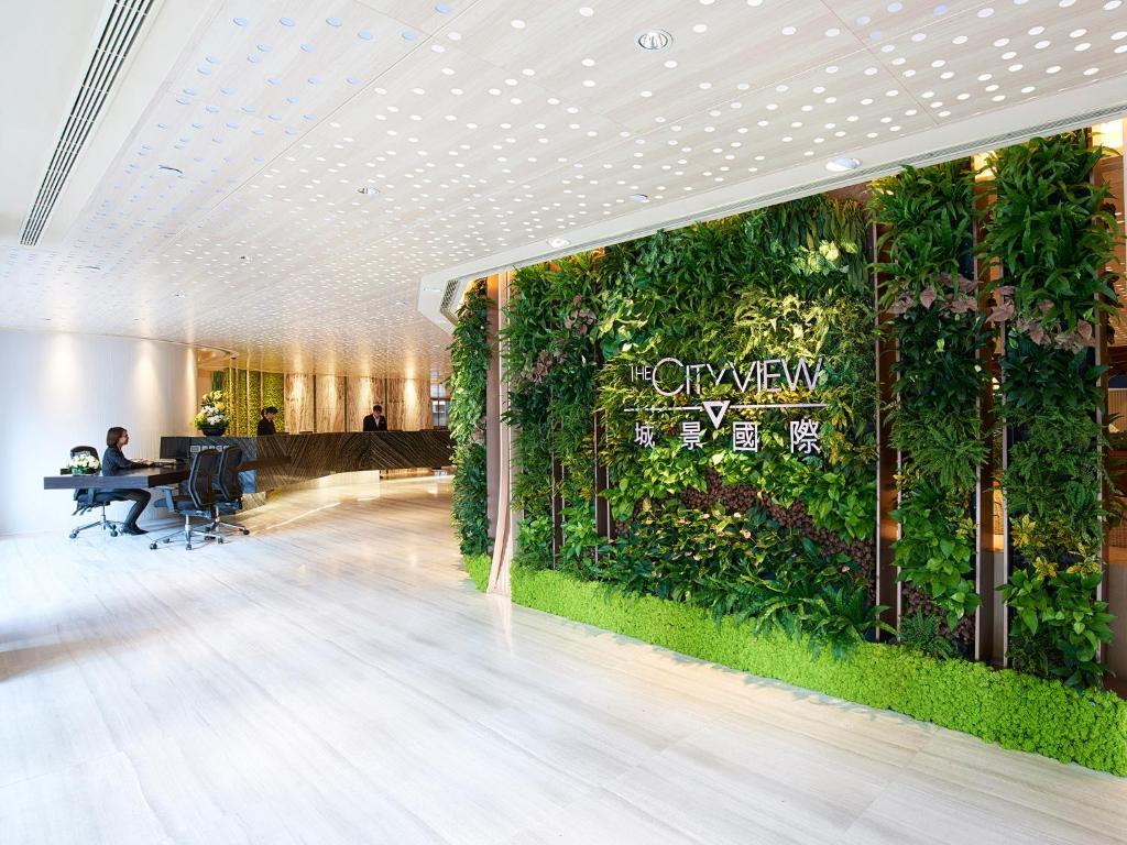 un hall de bureau avec un mur vert de plantes dans l'établissement The Cityview - Chinese YMCA of Hong Kong, à Hong Kong
