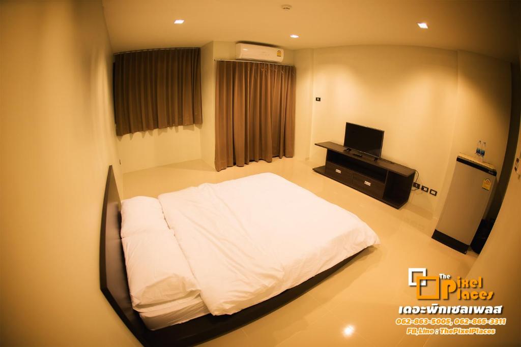 a hospital room with a bed and a television at The Pixel Places in Nonthaburi