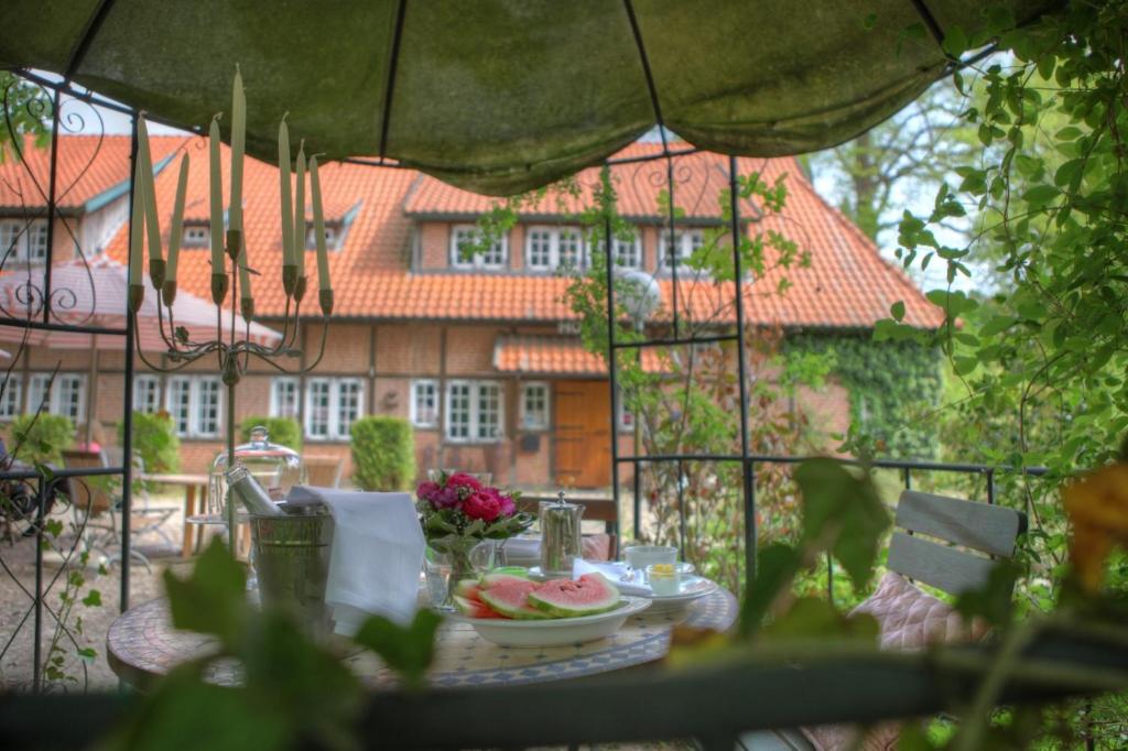 ein Tisch mit einer Schüssel Essen und ein Haus in der Unterkunft Hotel Grander Mühle in Kuddewörde