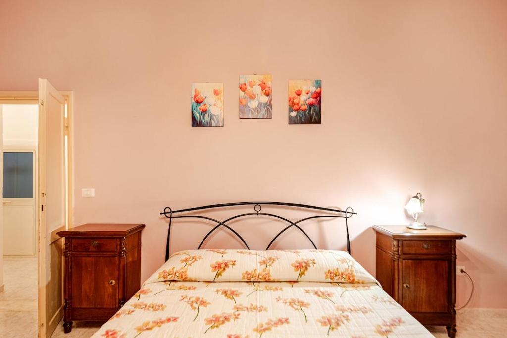 a bedroom with a bed and three paintings on the wall at Residenza Torre Antica - Nel Cuore di Viterbo in Viterbo
