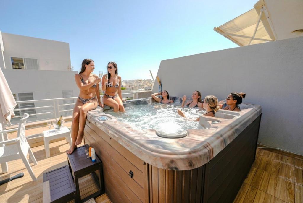 a group of women in bathing suits sitting in a hot tub at Apartment with Private Jacuzzi and Terrace in St Julians 3 Bedrooms in St. Julianʼs