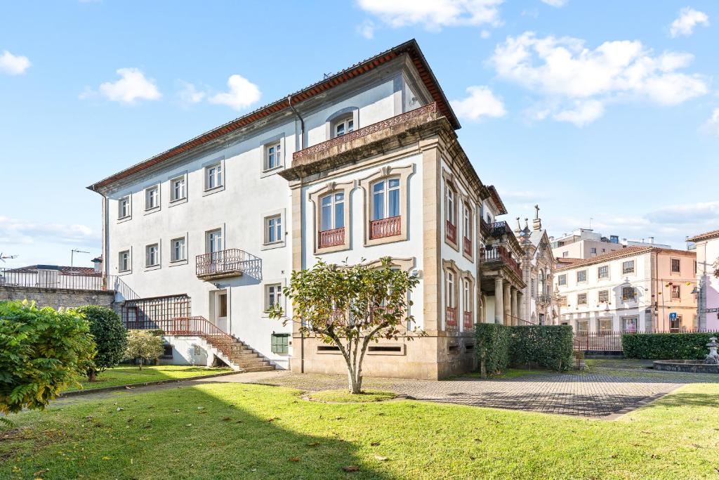 a large white building with a tree in front of it at Vale do Vez in Arcos de Valdevez