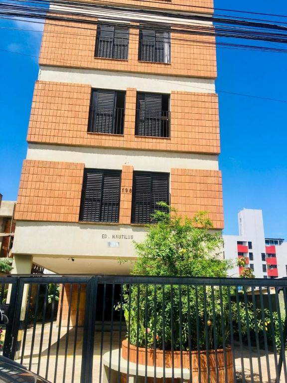 a tall brick building with black shuttered windows at Edifício Nautilus in Guarujá