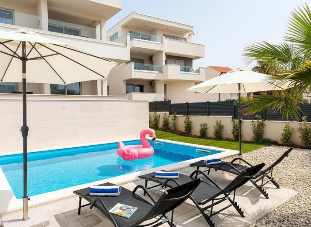 a swimming pool with a pink swan in the middle at Villa Poseidon in Novalja