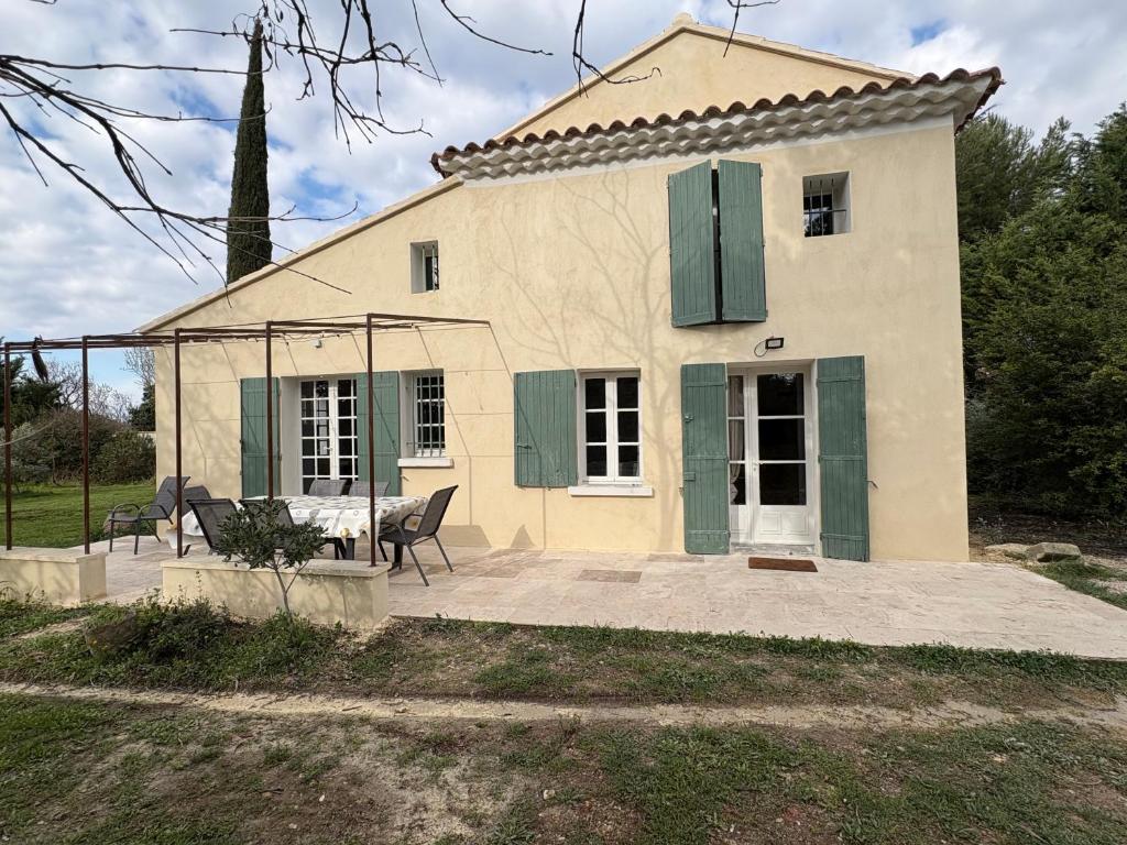 a house with a table and chairs in front of it at le mas au pied du Ventoux in Carpentras