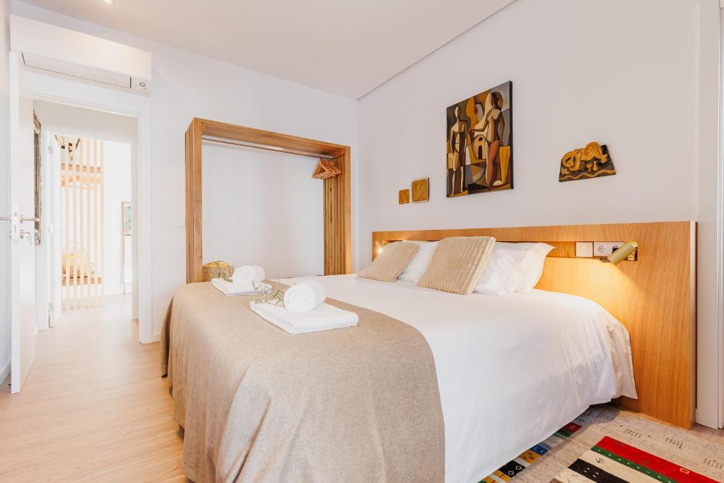 a bedroom with a large white bed and a window at Laranjal Rive Gauche in Tavira