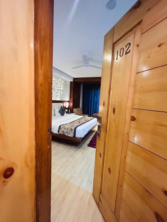 a bedroom with a bed and a door with the number at mayur Mora in Rāmgarh