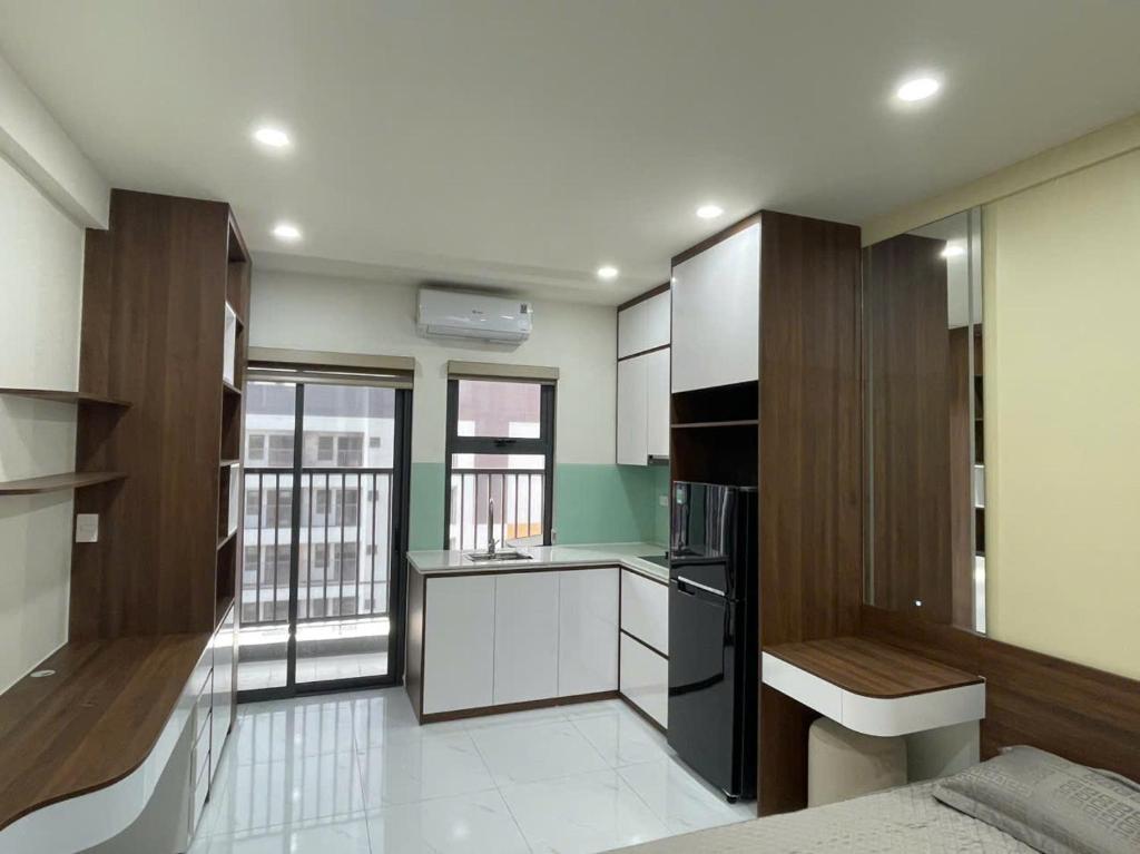 a kitchen with white cabinets and a black refrigerator at Trang Due homestay in An Dương