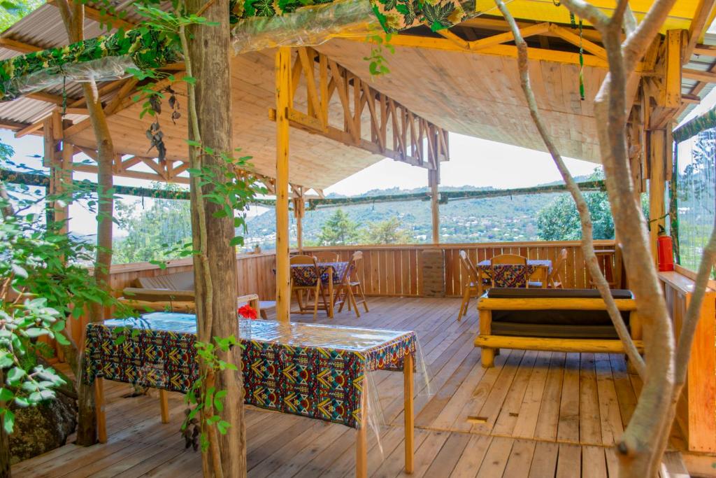 a wooden deck with tables and chairs on it at Aika Sunrise - Your Home in the Hills in Iringa