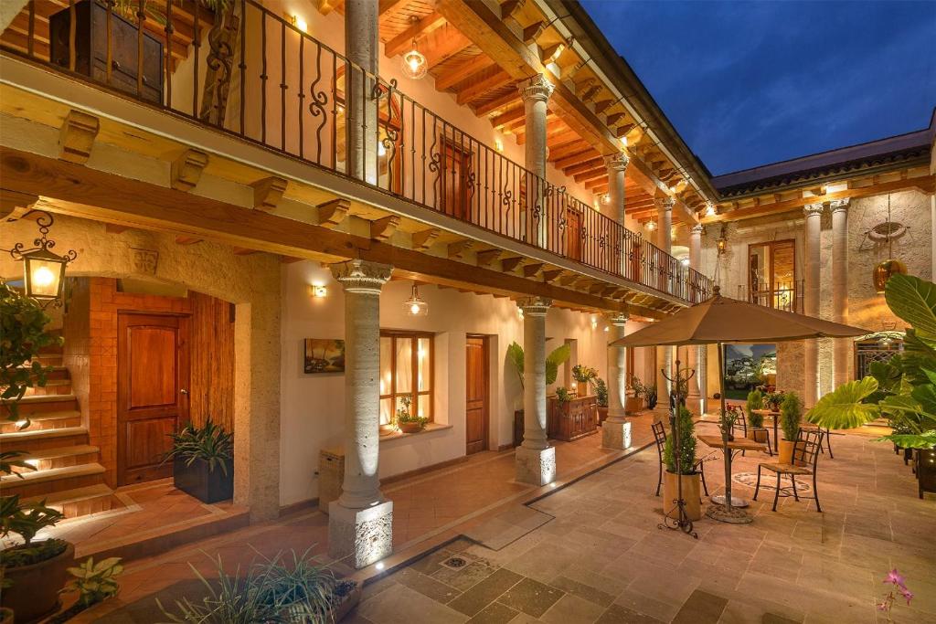 a large house with a balcony with a table and chairs at Hotel Boutique Siete Soles in Pátzcuaro