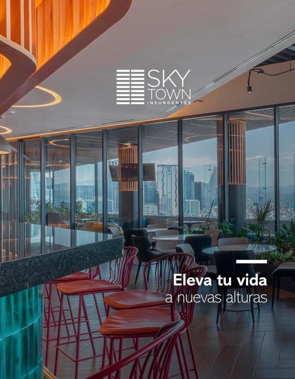 a restaurant with red chairs and tables and windows at Loft Vista Revolución in Mexico City