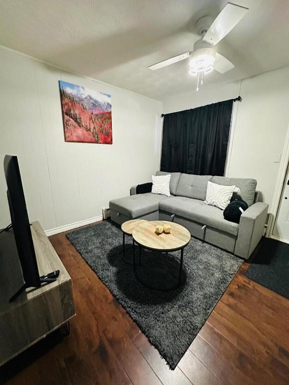 a living room with a couch and a table at Cozy Private Apartment with 2 Queen size Beds in Moncton
