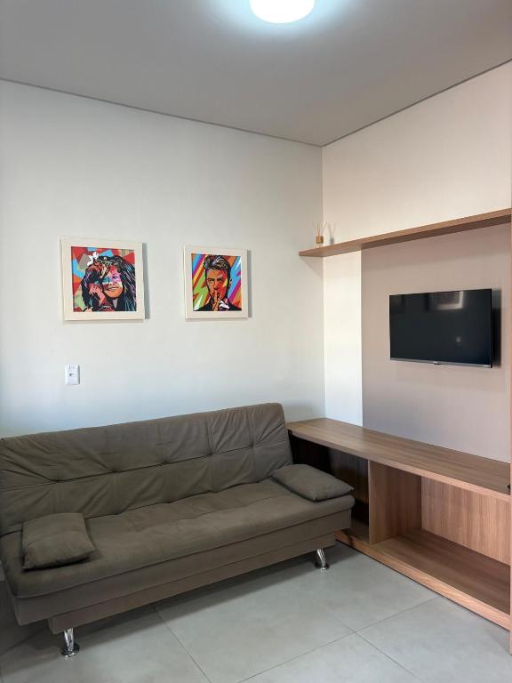 a living room with a couch and a flat screen tv at Studio J&C in Primavera do Leste