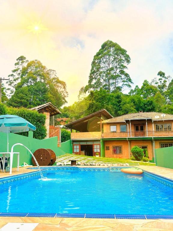 a swimming pool in front of a house at Pousada All Green - Monte Verde in Monte Verde