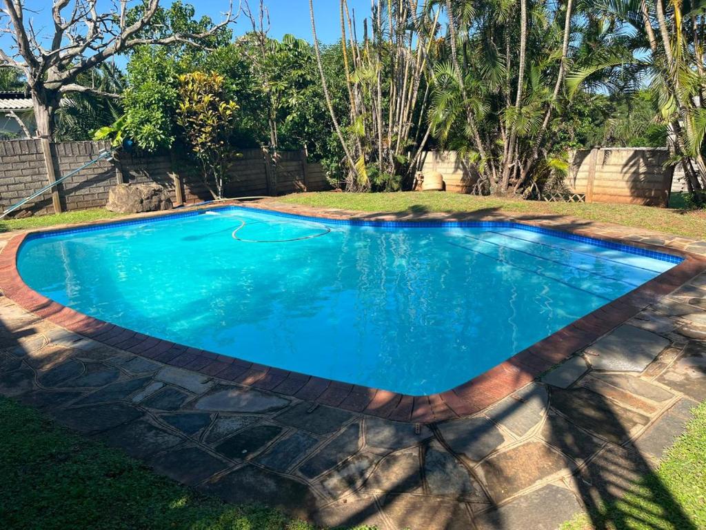 a swimming pool with blue water in a yard at Hawthorne By The Sea in Kingsborough