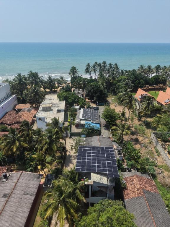 an aerial view of solar panels on the roofs of houses and the ocean at Mollusca Beach Villa in Waskaduwa