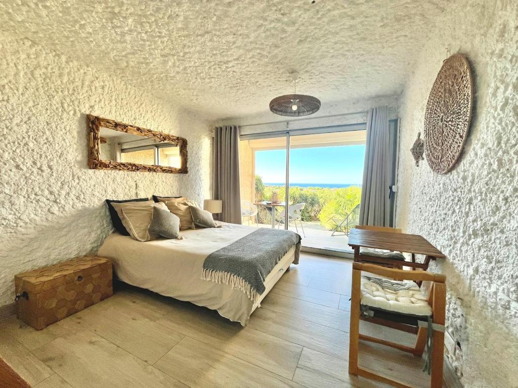 a bedroom with a bed and a desk and a window at Beautiful sea view studio in Lumio