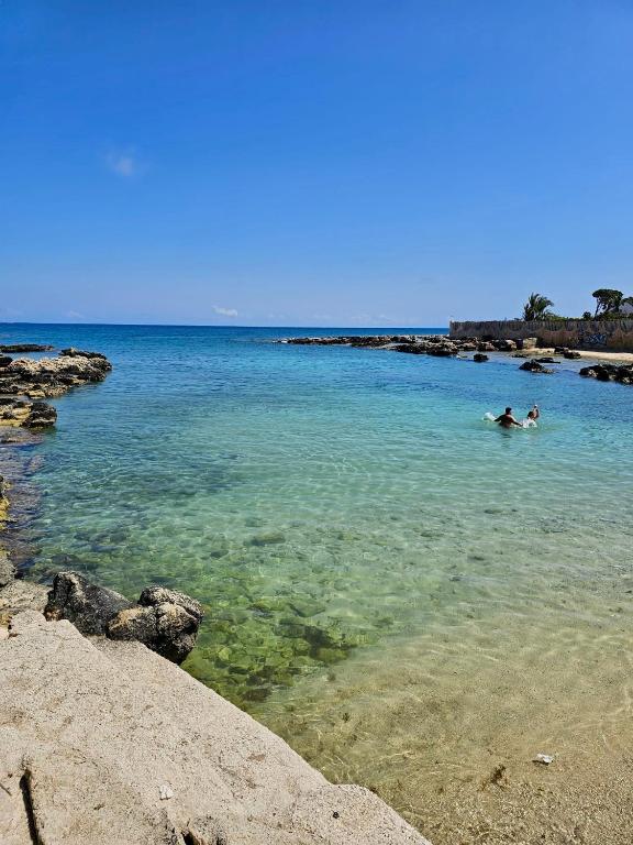 two people swimming in a body of water at Aquarium - Villa con accesso al mare - parcheggio in San Vito